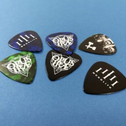 Dark blue, green, and black guitar picks with a white on-body print