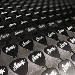 Black guitar picks with a white on-body print